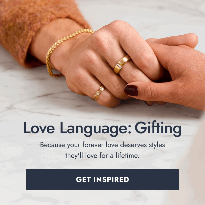 Two hands gently holding, showcasing gold rings and bracelets. Love Language: Gifting. Click here to Get Inspired