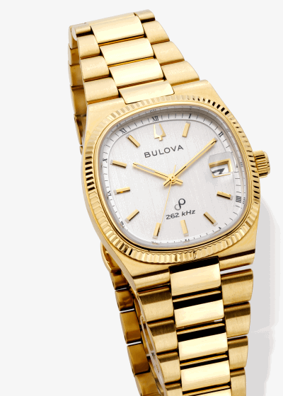 Bulova gold-tone stainless steel watch with white dial, fluted bezel, and date window.