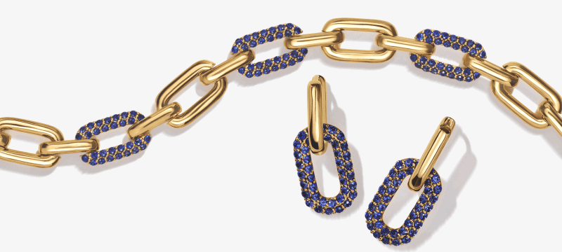 Yellow gold link chain necklace and matching drop earrings with blue pavé-set stones.