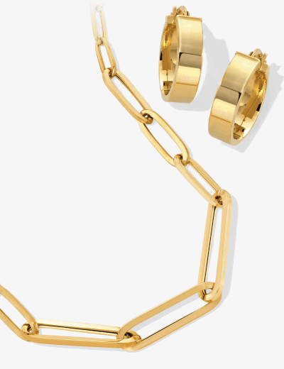 Yellow gold paperclip chain necklace paired with wide polished gold hoop earrings.