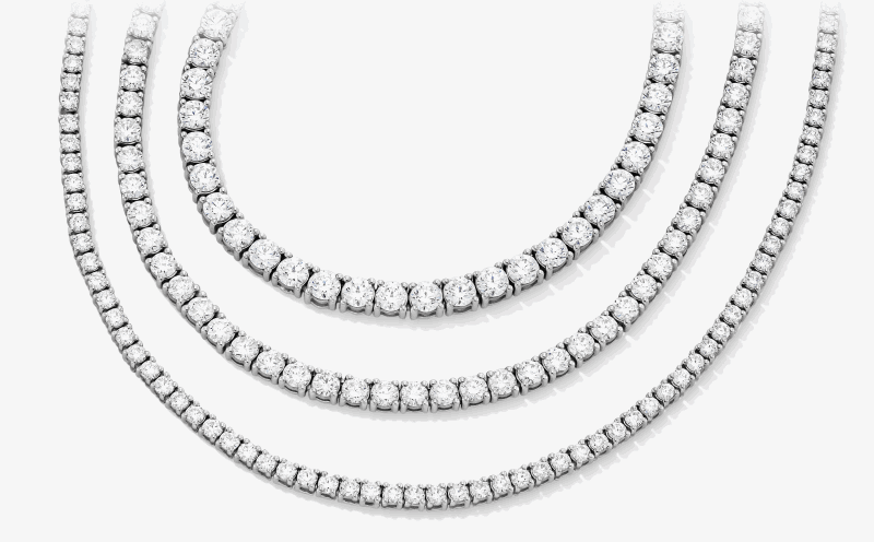 Three layered white gold diamond tennis necklaces in graduated lengths.
