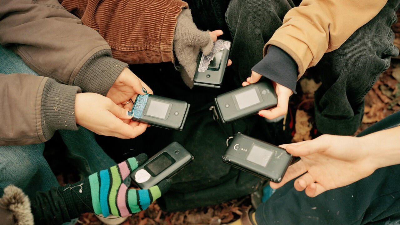 Luddite Club members hold out their matching old flip phones. The high school group promotes a lifestyle of self-liberation from social media and technology.