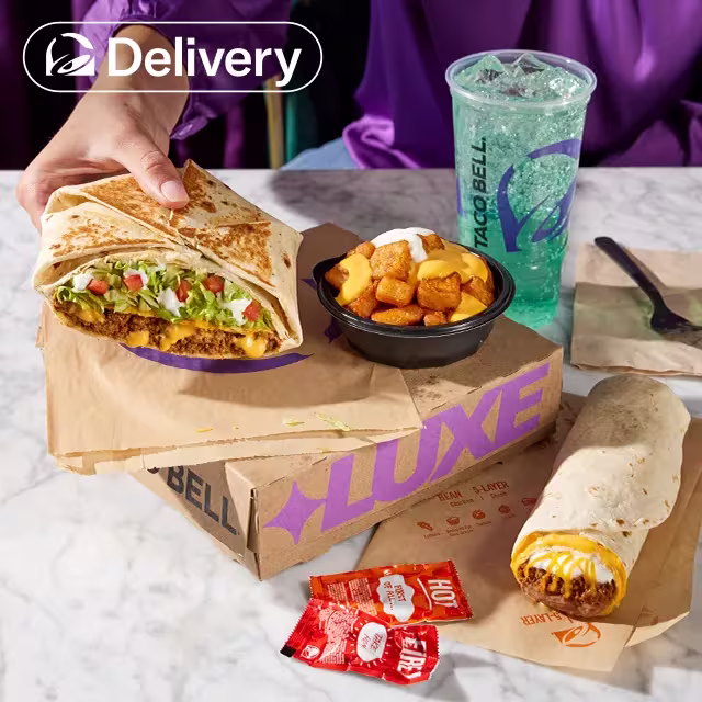 A person standing behind a table displaying a Luxe Cravings Box.