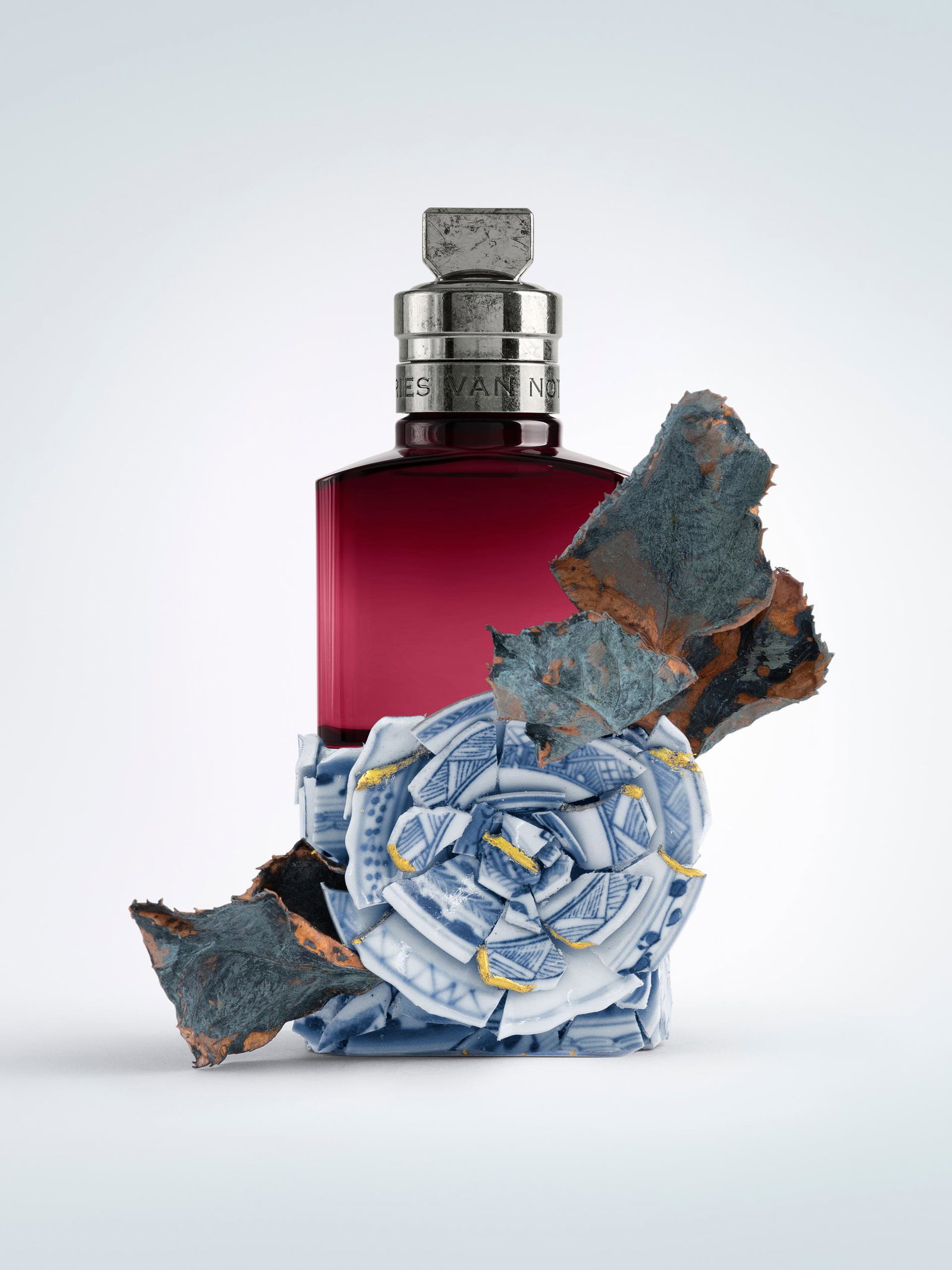 Perfume bottle with rose decorative elements on a light grey background - Dries Van Noten