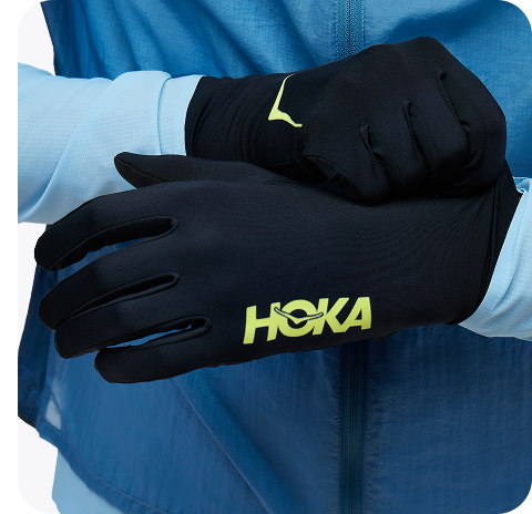 Images of two people posing wearing the Trail Run Vest in White, a person wearing the Airolite Arm Sleeves in HOKA Blue, and a person wearing the Airolite Run Gloves in Black.