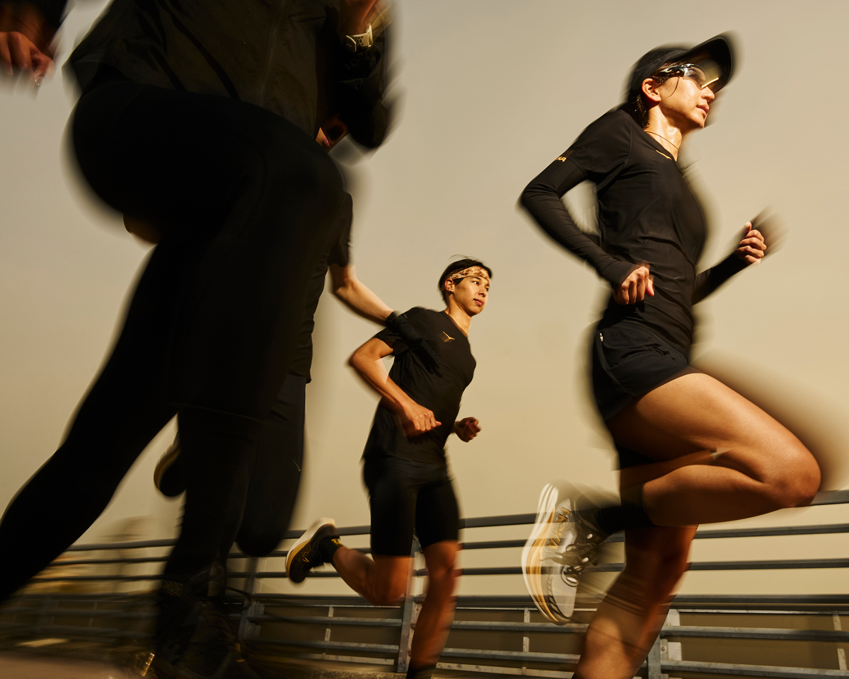 A blurry image of a group of people running in all black clothing.