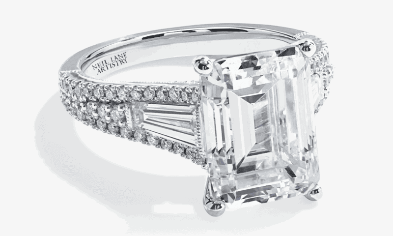 White gold emerald cut diamond engagement ring with a three row pavé diamond band.