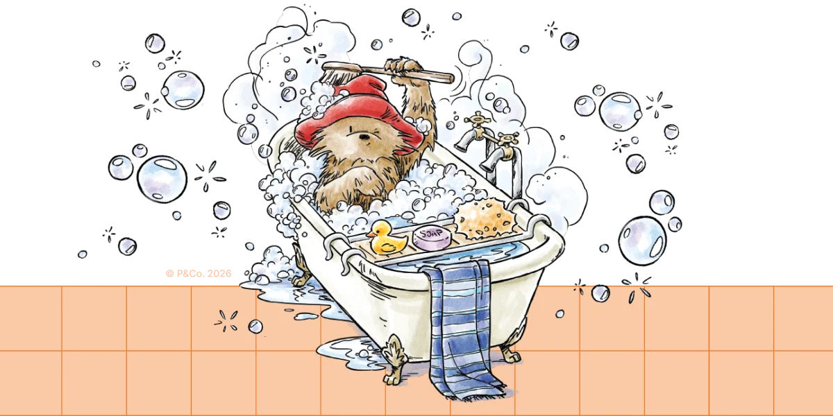 Illustration: Paddington bathing in a bath tube surrounded by bubbles / © P&Co. 2026