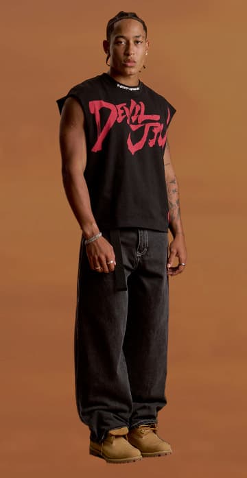 an image of a man standing in a black shirt and jeans