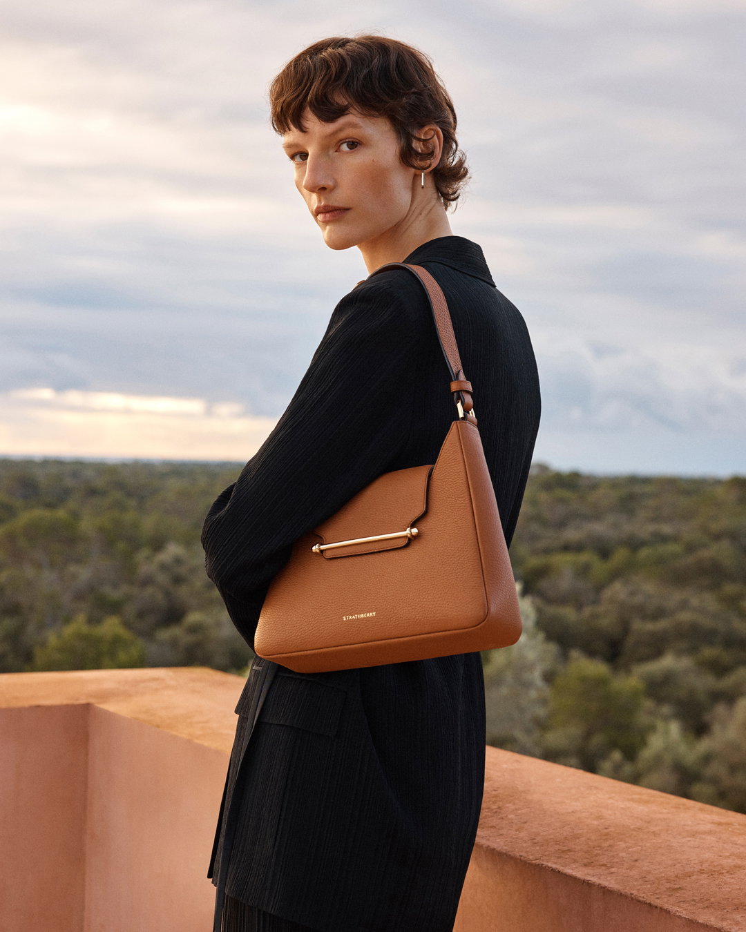 an image of a woman standing on a balcony with a handbag