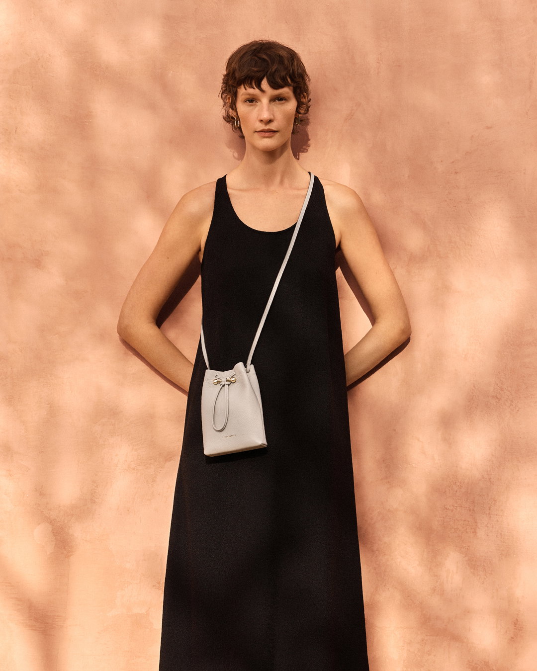an image of a woman in a black dress and a white purse