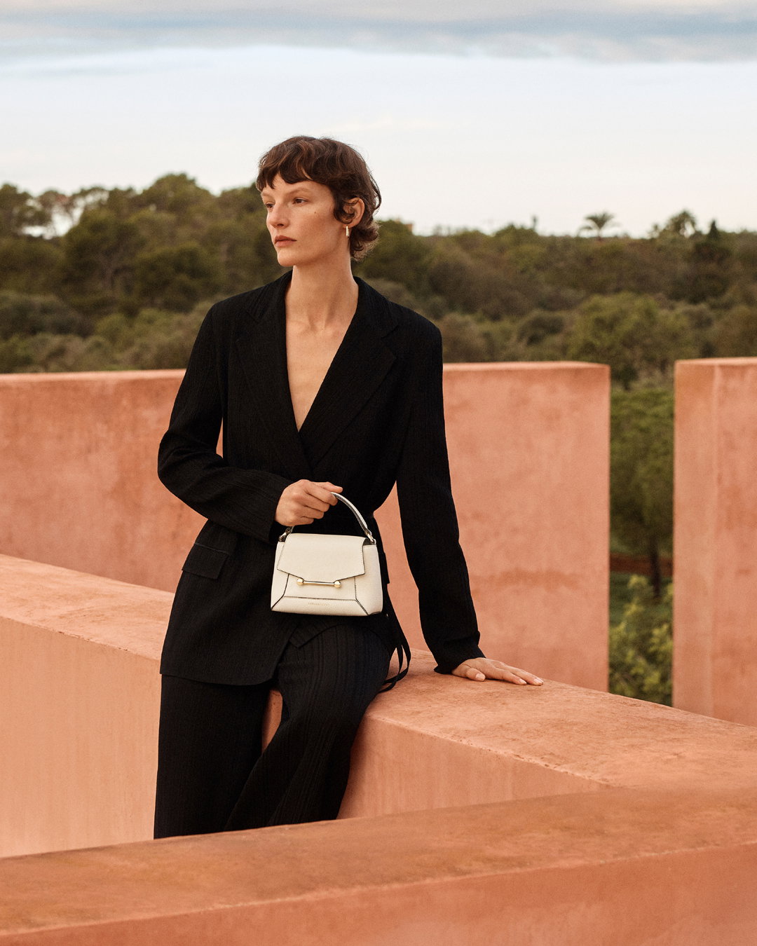 an image of a woman in a black dress and a white purse