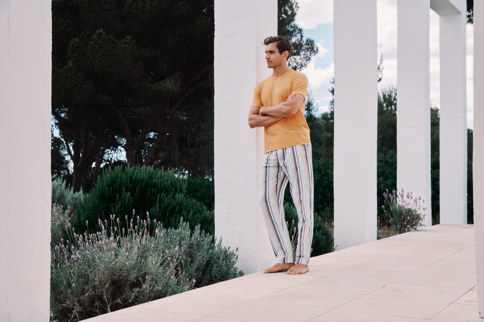 an image of a man standing on a porch with his arms crossed
