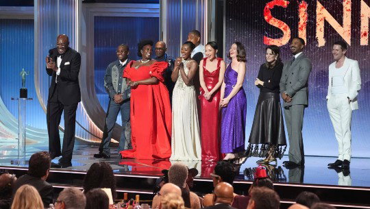 The 'Sinners' cast accepts a trophy on stage at the Actor Awards