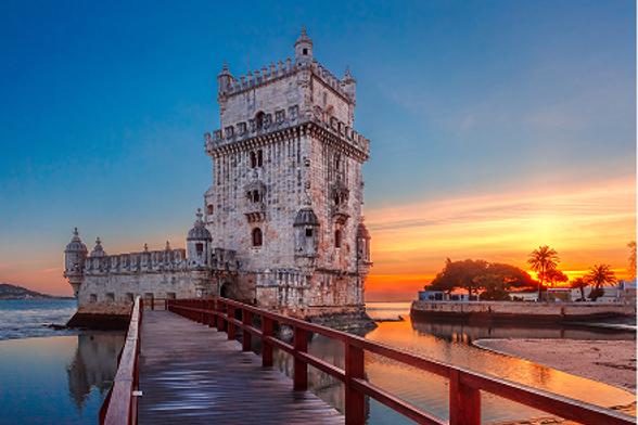 Belem Tower at sunset with a wooden boardwalk.