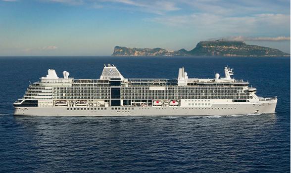 The Silver Ray cruise ship sails across blue waters with a distant island.