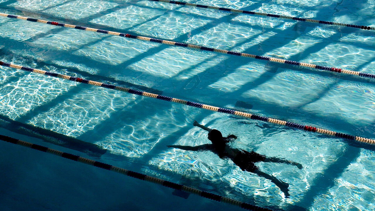 A student swims in a university pool.