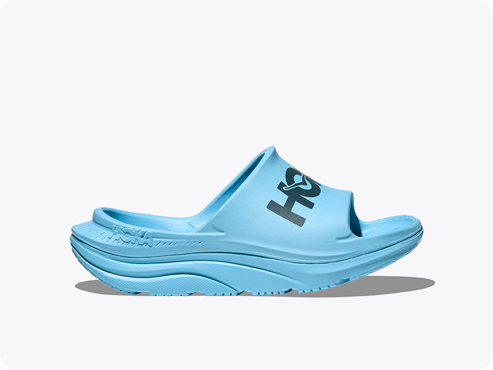 A side profile image of the Ora Athletic Slide recovery shoe in Soaring Blue / Faded Navy.