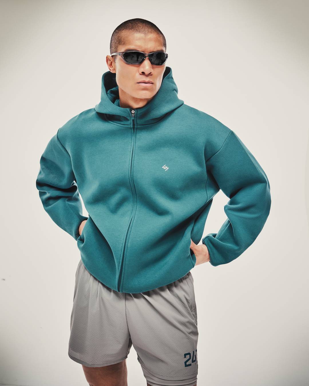 Model wearing the 247 Form Zip Hoodie in Teal