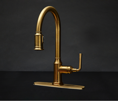 Sleek arched brass faucet with a brushed finish, warm metallic tones, graceful curves, and refined details set against a deep matte black backdrop.