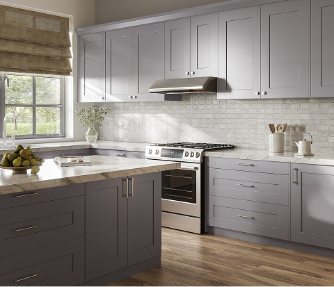 Image: A serene kitchen with lavender cabinetry, marble countertops, textured tile backsplash, brushed metal accents, warm wood flooring, and soft natural light.