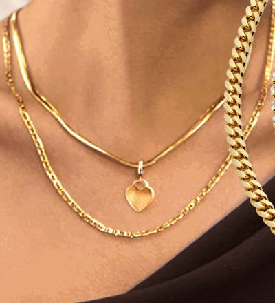 Model Wearing Yellow Gold Heart Pendant Necklace With Layered Chain.