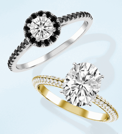 White gold white and black diamond round-cut engagement ring, and yellow gold white diamond oval engagement ring.