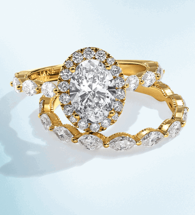 Yellow gold oval cut diamond engagement ring with matching wedding band.