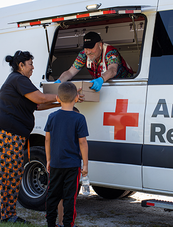 Man helping family with American red cross