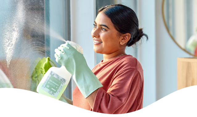 Woman smiling while cleaning a window