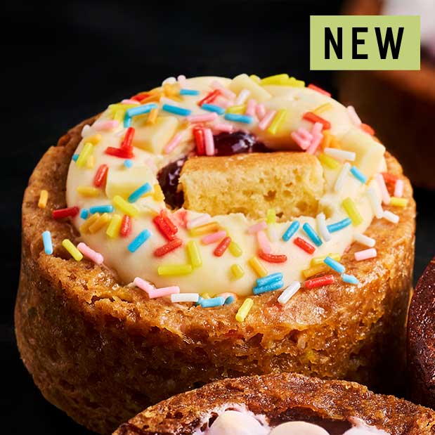 Chewy white chocolate chunk cookie, filled with cheesecake and topped with vanilla sponge