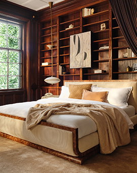 An Earth tone bedroom with a large shelving unit.