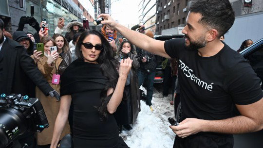 A crowd holds up their phones to Paige DeSorbo as she is styled by a man in a TRESemmé shirt