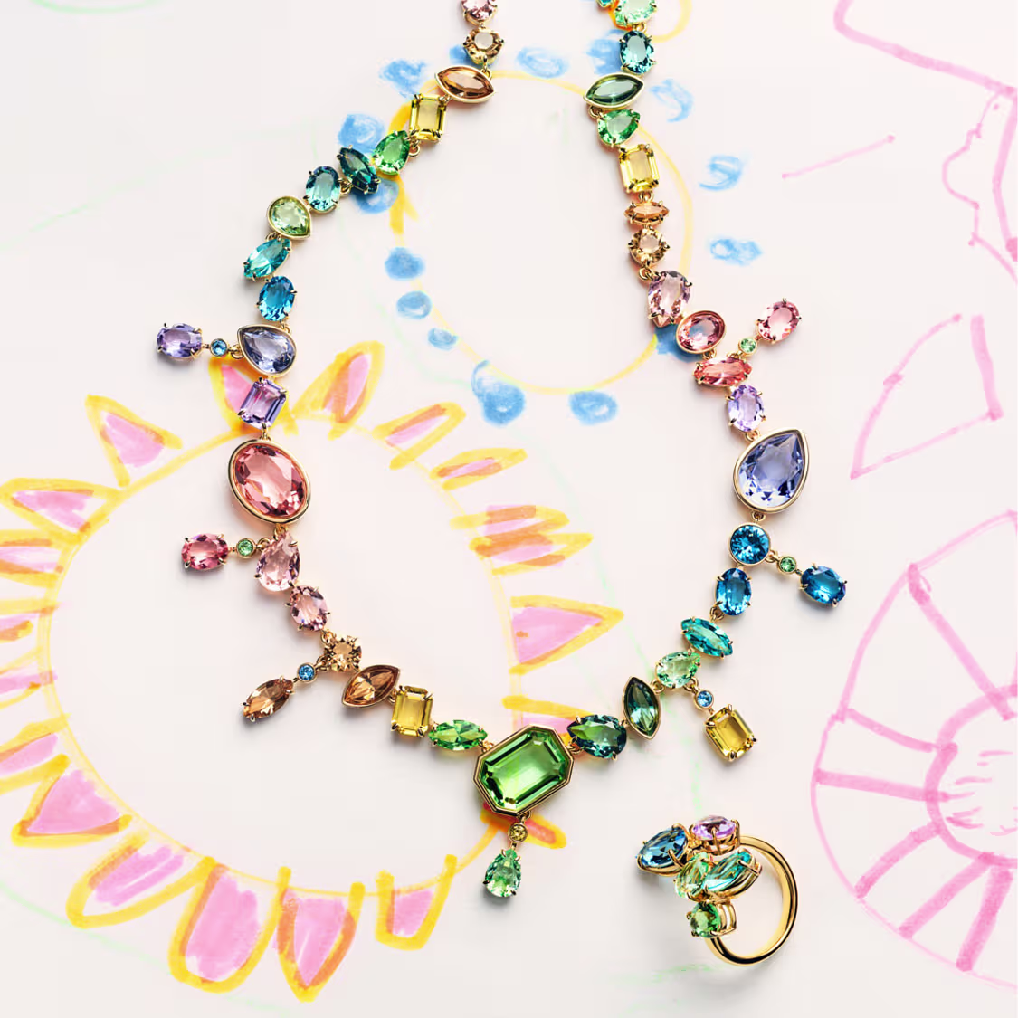 Collier et bague cocktail Gema, posés sur un dessin d’enfant