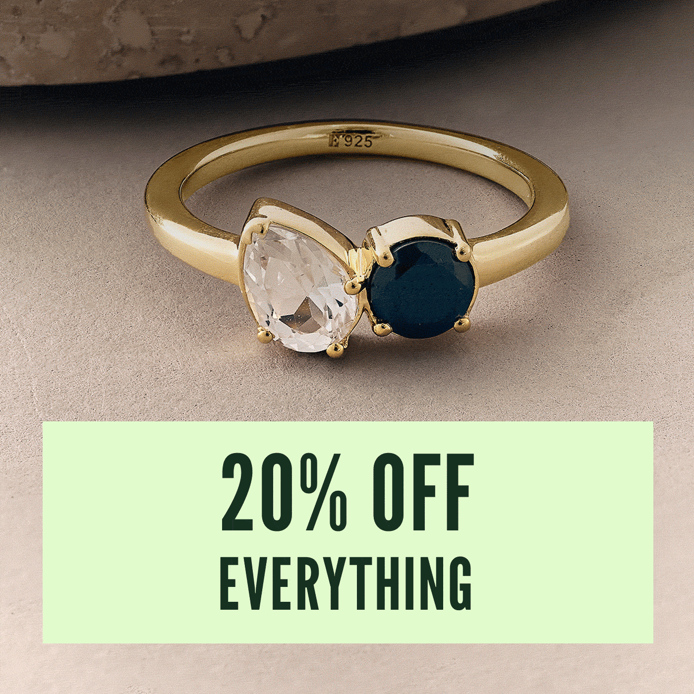an image of a gold ring with a blue stone and a white stone