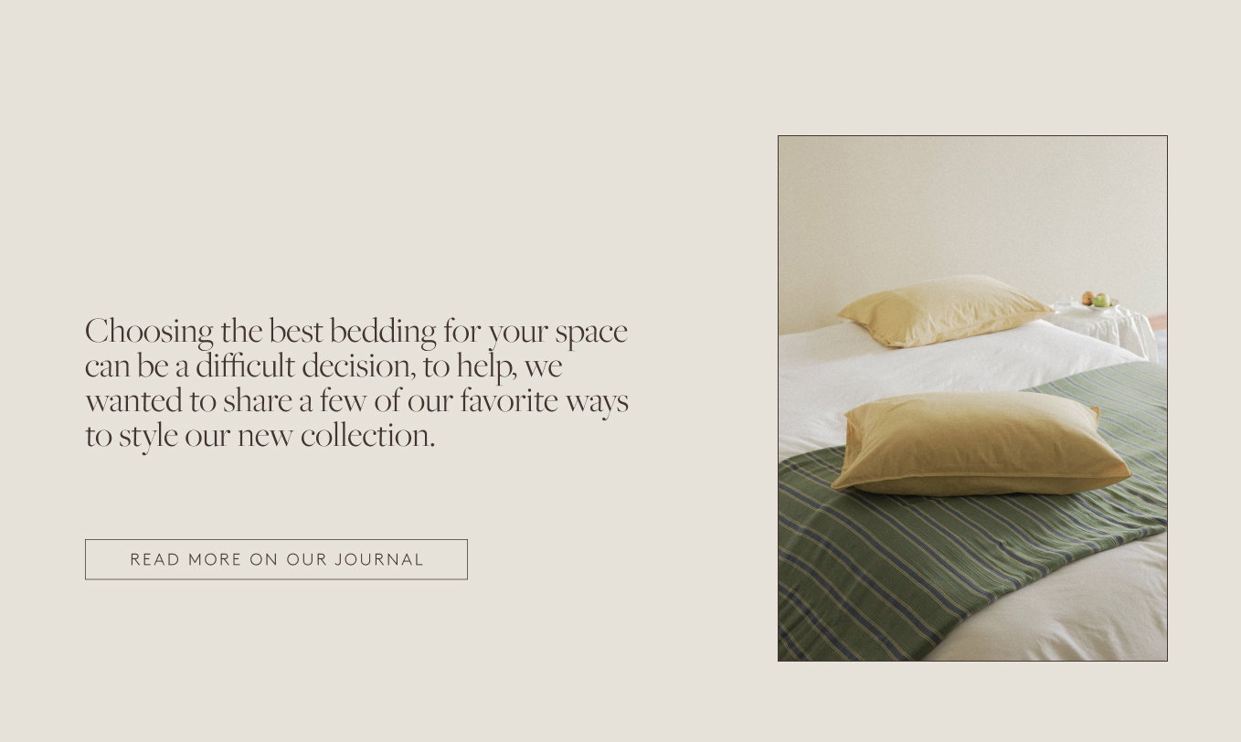 Light yellow pillow on top of a green stripe blanket on a bed