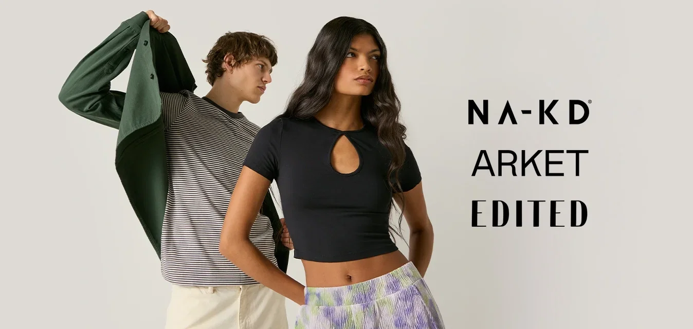 Jeune homme en train d'enfiler une veste verte par-dessus une chemise grise et un short crème ; jeune femme se tenant devant en crop top noir et pantalon tie-dye violet.