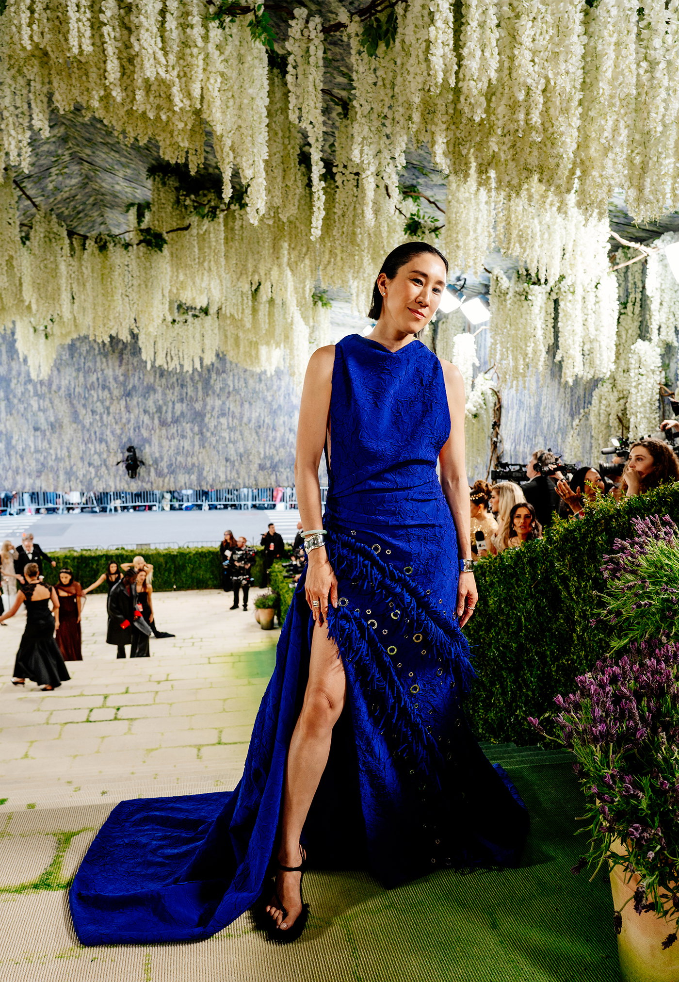 Image of Eva Chen, Instagram's VP of Fashion, wearing a custom dress in Yves Klein Blue in plissé-bonded fabric, standing at the top of the Met Gala Red Carpet. 
