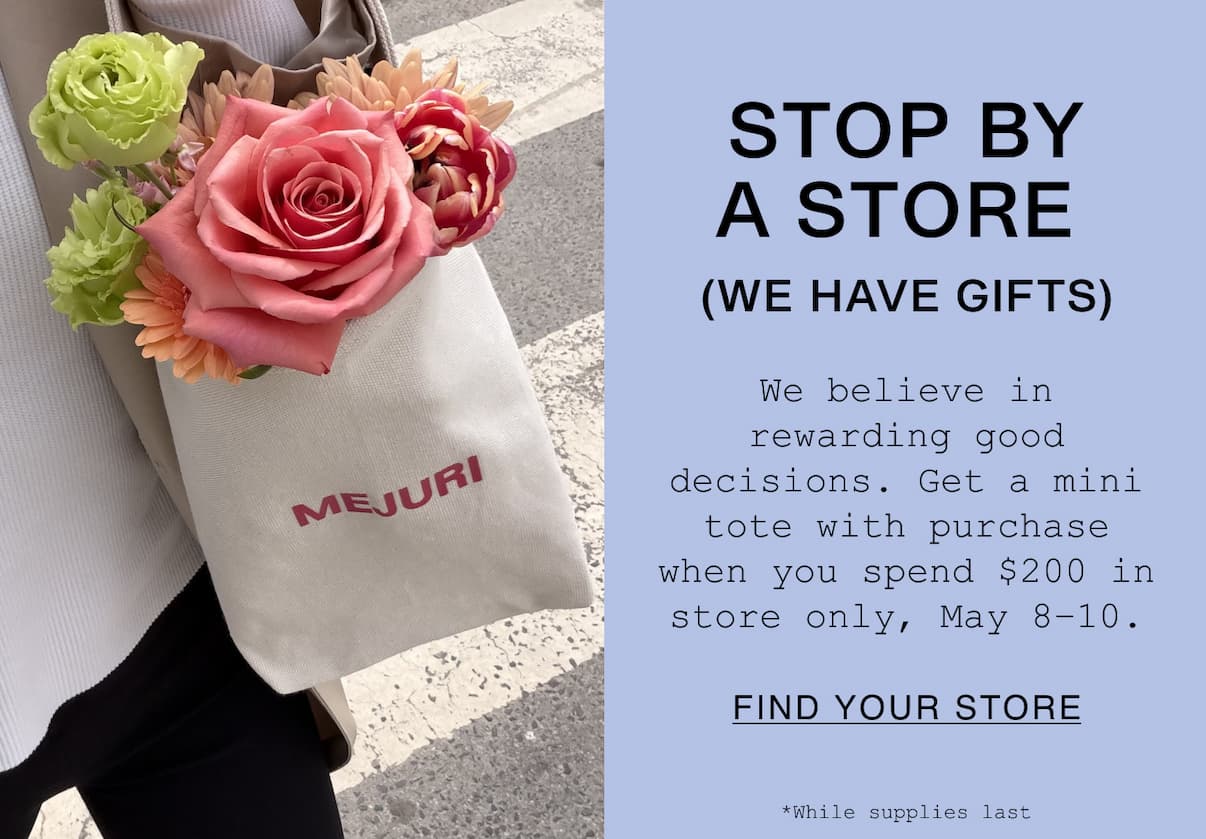 Mejuri canvas mini tote filled with pink roses and spring flowers. Text reads: STOP BY A STORE (WE HAVE GIFTS). Get a mini tote with purchase when you spend $200 in store only, May 8–10. While supplies last.