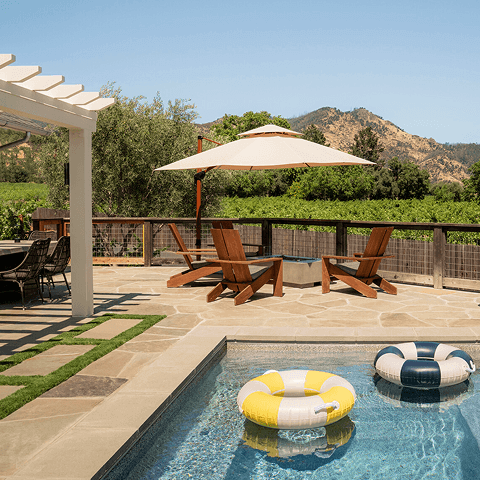 Private pool terrace with loungers, umbrellas, and vineyard views beyond.