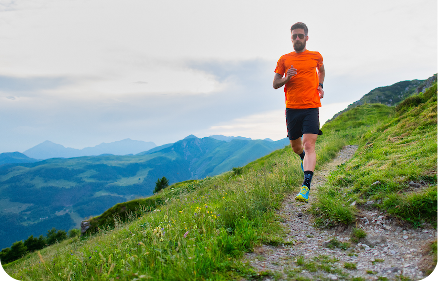 middle aged man running trails in the mountains