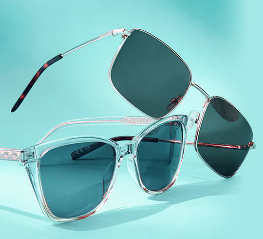 Two pairs of sunglasses, one clear-framed and one dark-framed, on a teal background