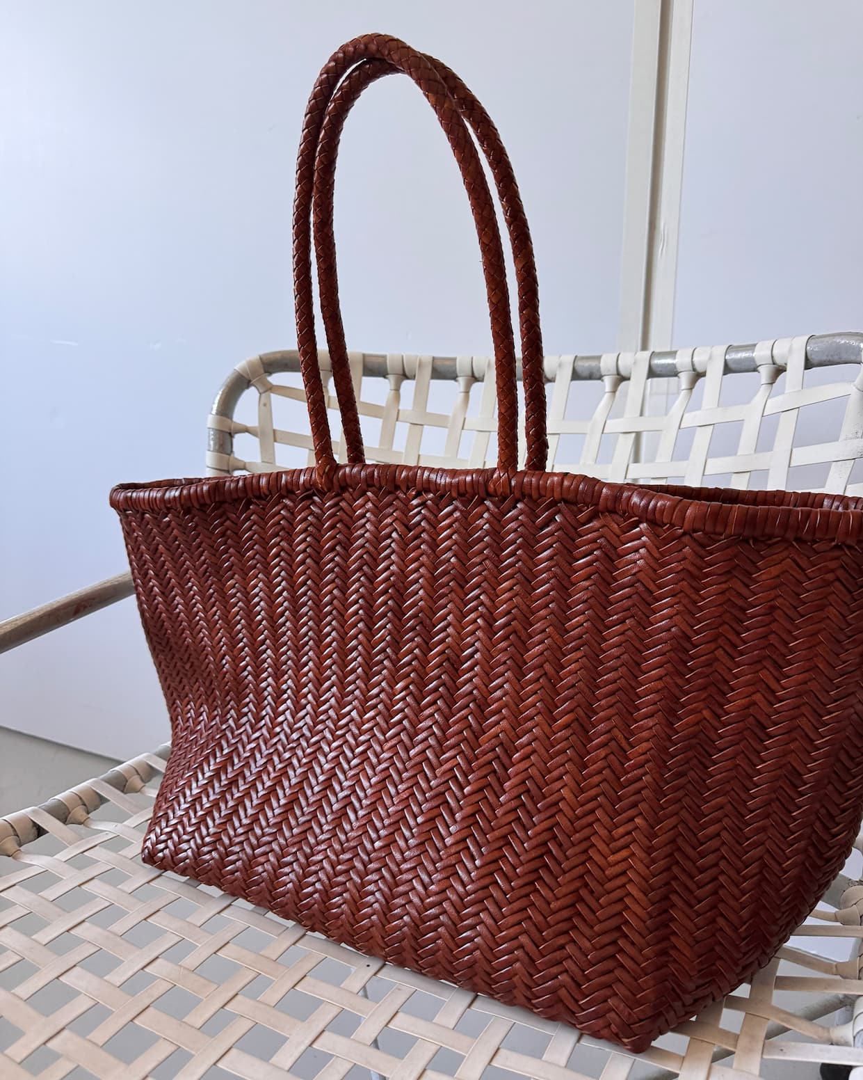 the woven mercato bag on a white woven chair