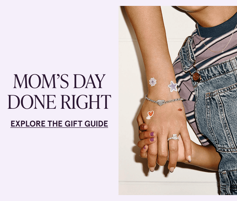 A child holding a parent’s hand clad in jewelry and stickers. Mom’s Day done right. Click here to explore the gift guide