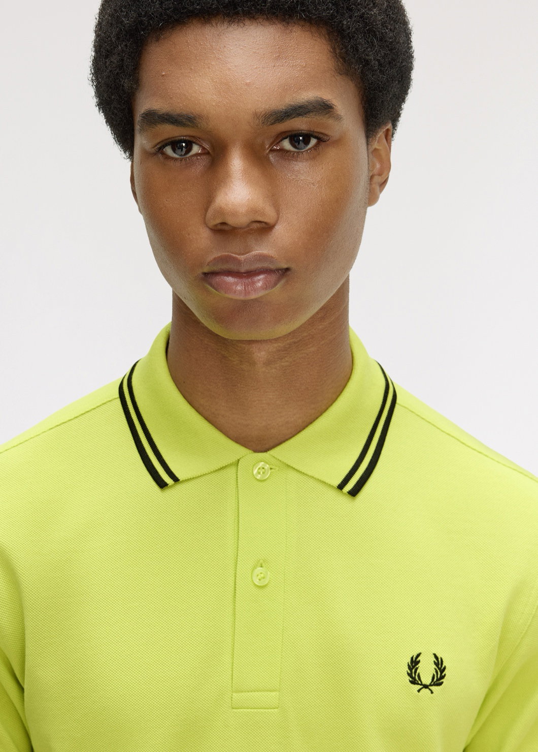 Male model wearing a Fred Perry Shirt in Tennis Ball Yellow with black twin tipping