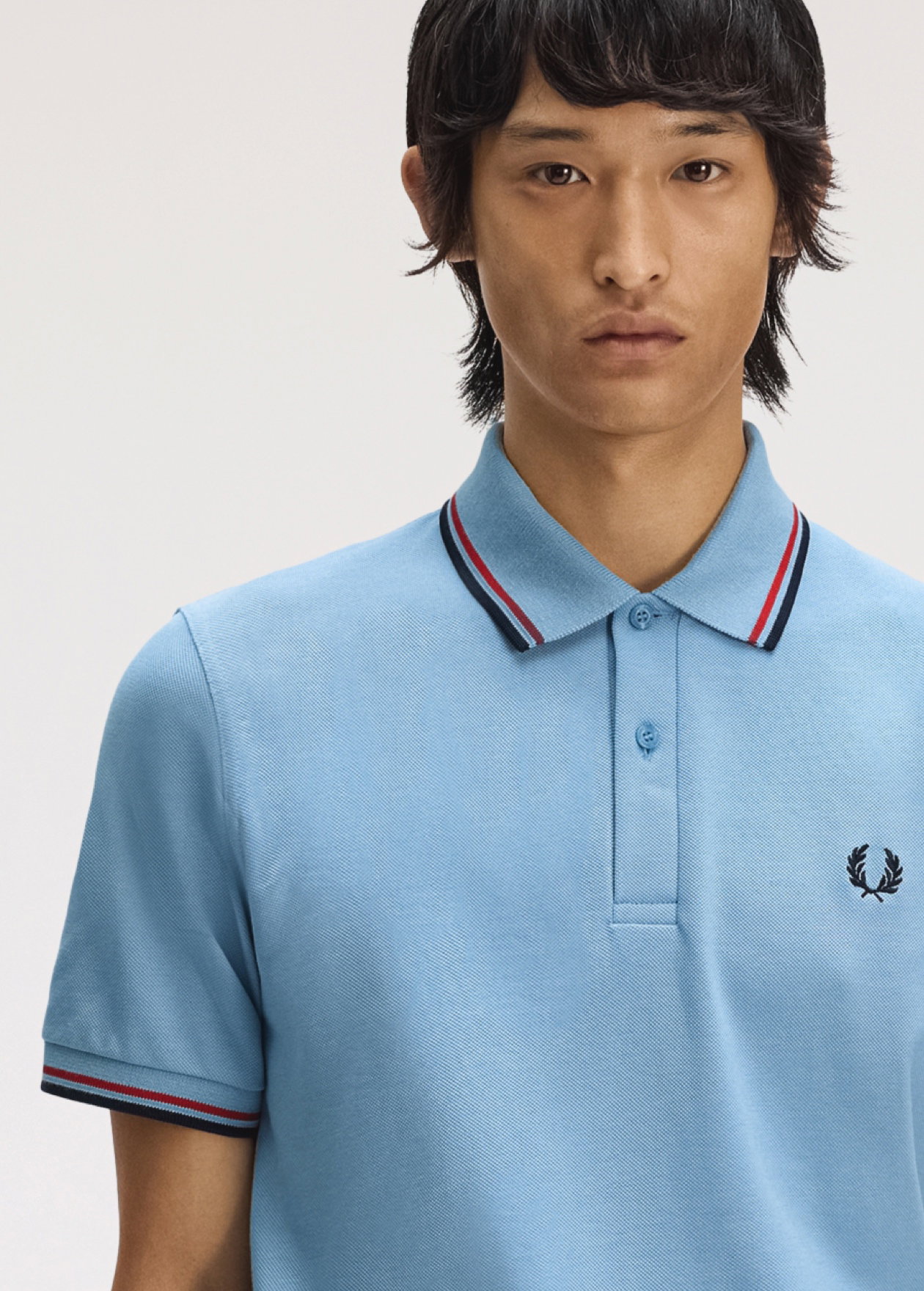 Male model wearing a M12 Fred Perry Shirt in Sky / Red / Navy