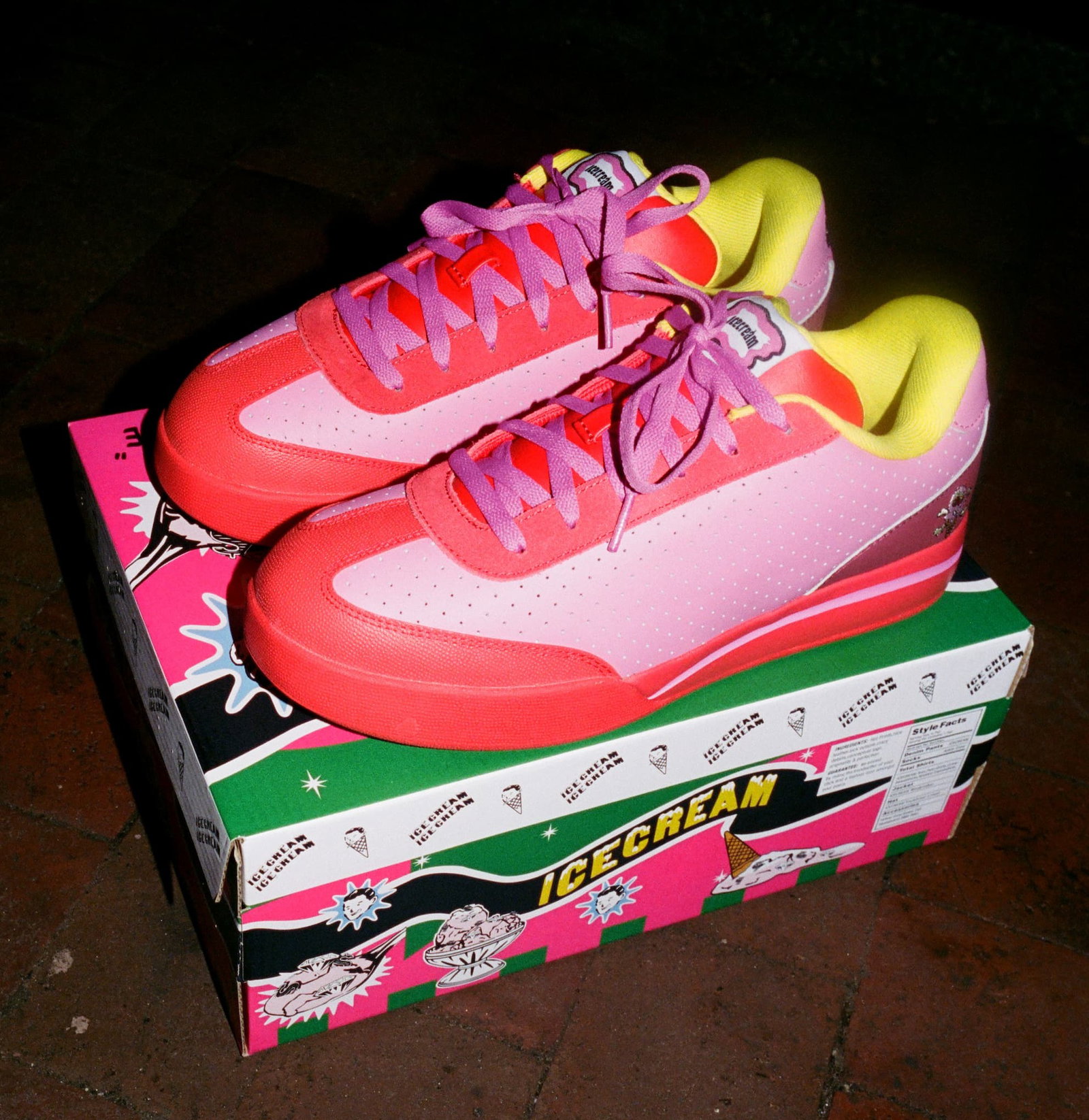Reebok Board Flip sneakers in bright pink and red with yellow lining displayed on stacked shoeboxes.
