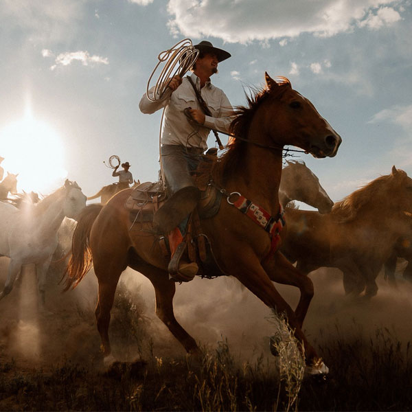 Cowboy on a horse wearing a pair of Tony Lama boots.