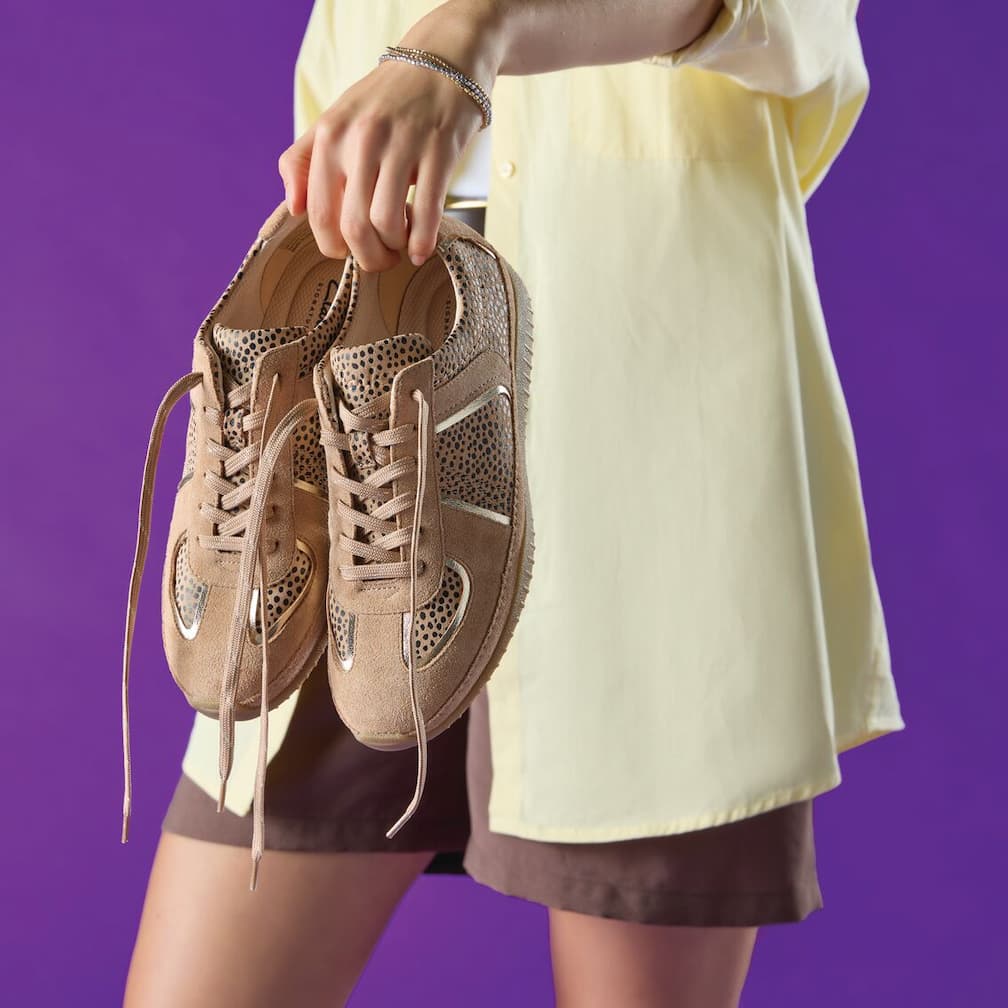 Model holding Clarks trainers