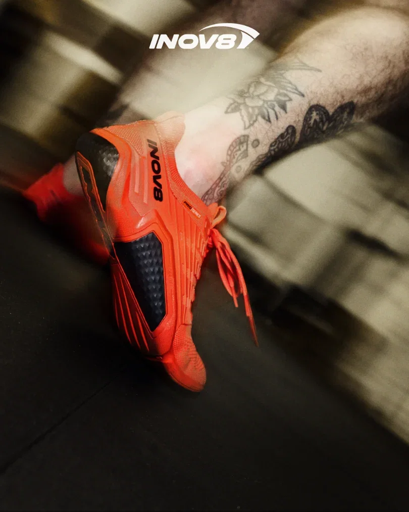 A bright orange barefoot shoe flexing up from a gym shoe